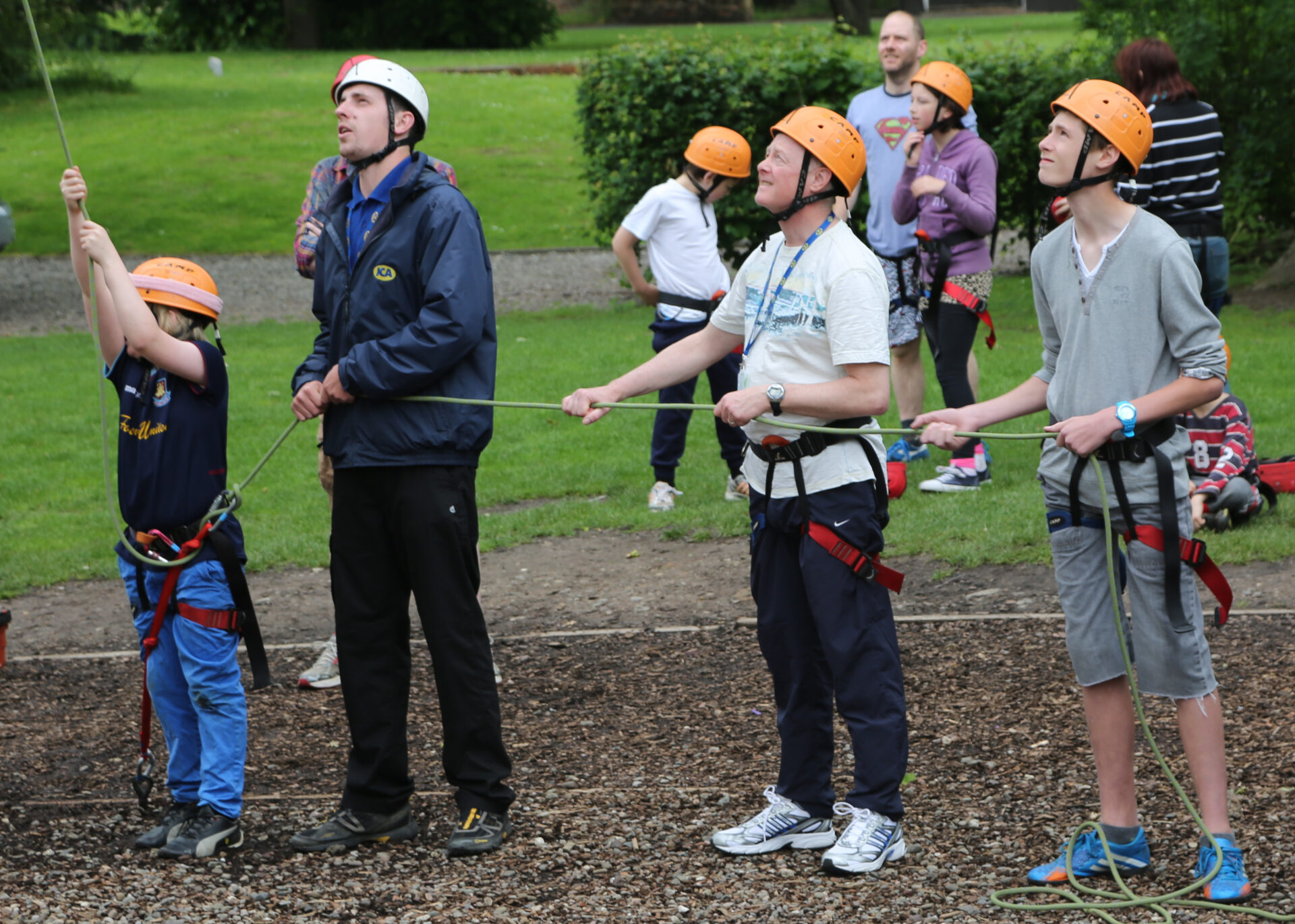 Four people holding the rope for abseiling