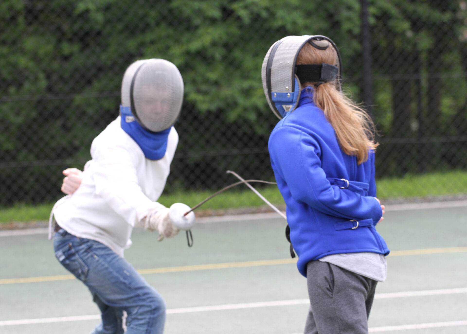 Two children participating in a fencing activity