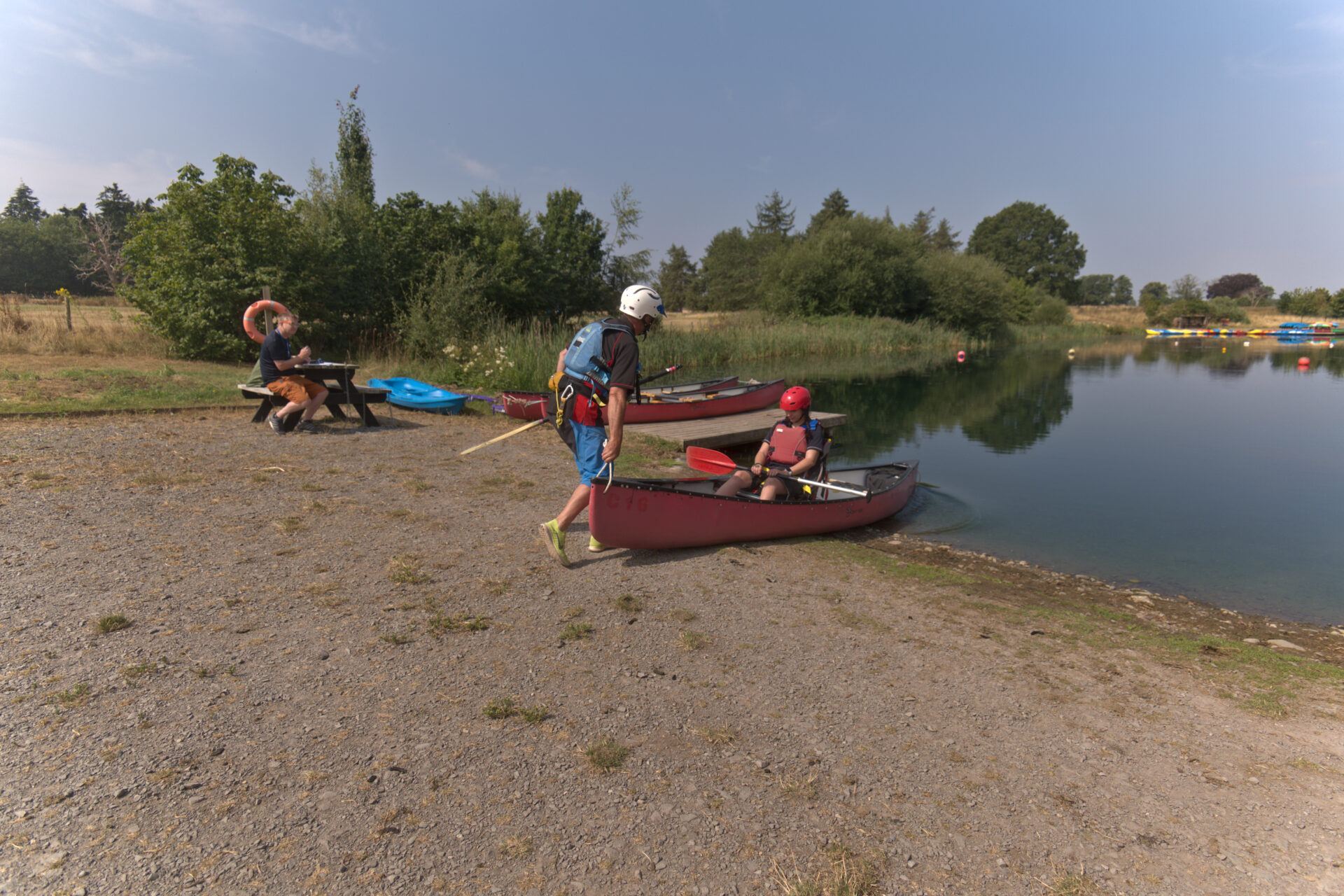 Instructor launching a canoe with a young person in an adapted seat