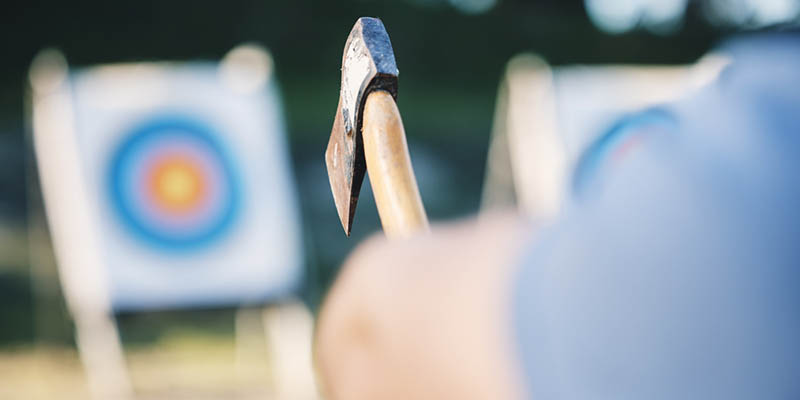 Man throwing an axe at a wooden target